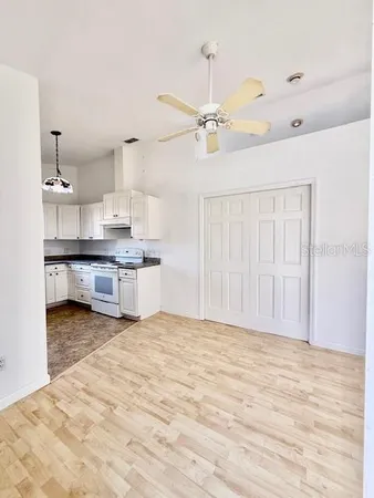 a view of kitchen with granite countertop cabinets and refrigerator