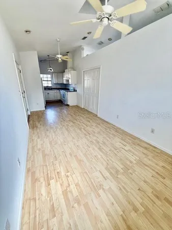 a view of empty room with wooden floor