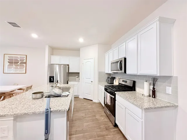 a kitchen with stainless steel appliances granite countertop a sink stove and refrigerator