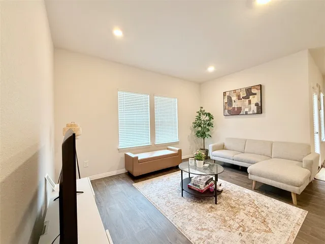 a living room with furniture window and a wooden floor