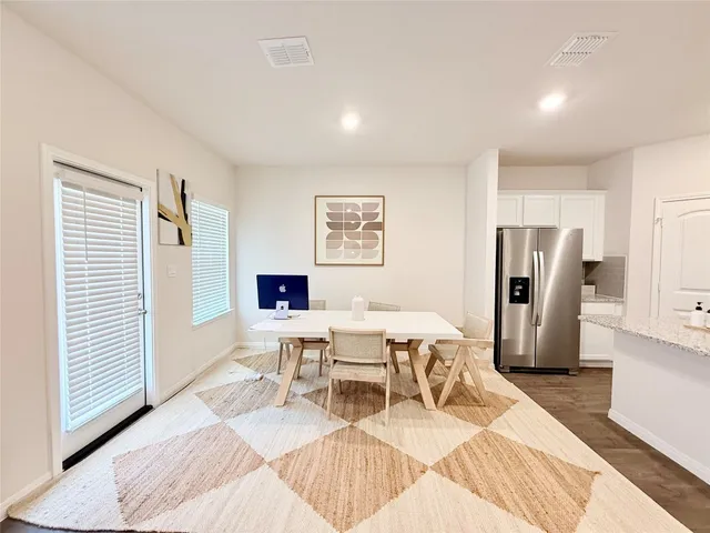 a living room with furniture a large window and stainless steel appliances