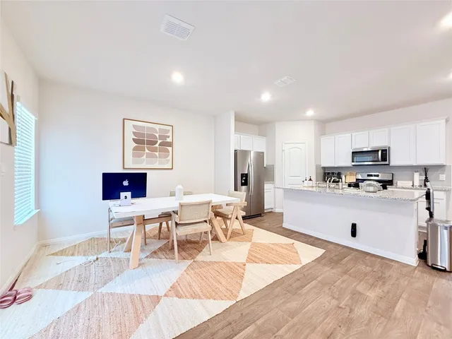 a living room with stainless steel appliances kitchen island granite countertop a refrigerator and a sink