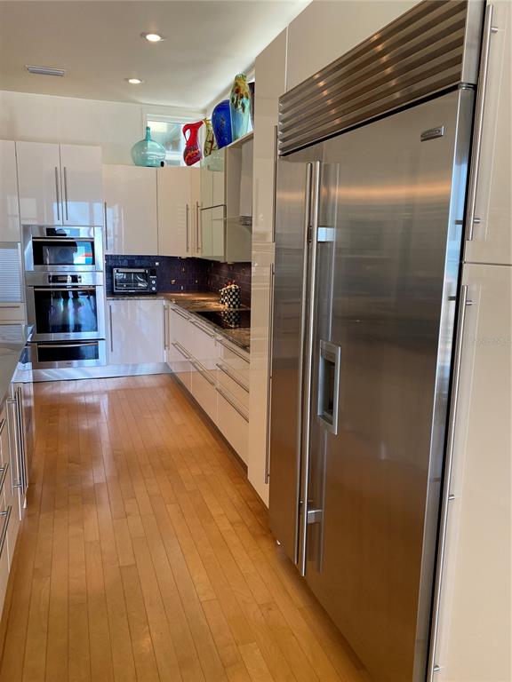 1522 Gulf Boulevard Indian Rocks Beach, FL 33785 - Photo 21 of 52 a kitchen with stainless steel appliances granite countertop a refrigerator and a stove