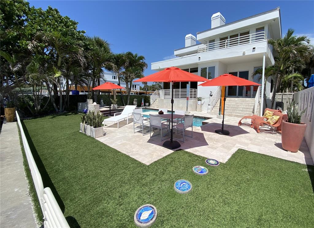 1522 Gulf Boulevard Indian Rocks Beach, FL 33785 - Photo 27 of 52 a view of a patio with a table and chairs under an umbrella