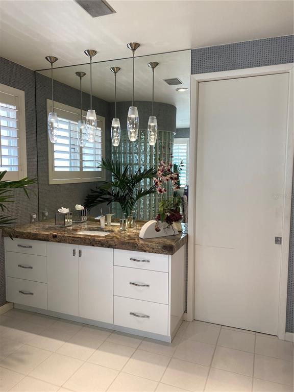 1522 Gulf Boulevard Indian Rocks Beach, FL 33785 - Photo 37 of 52 a bathroom with a granite countertop sink and a mirror