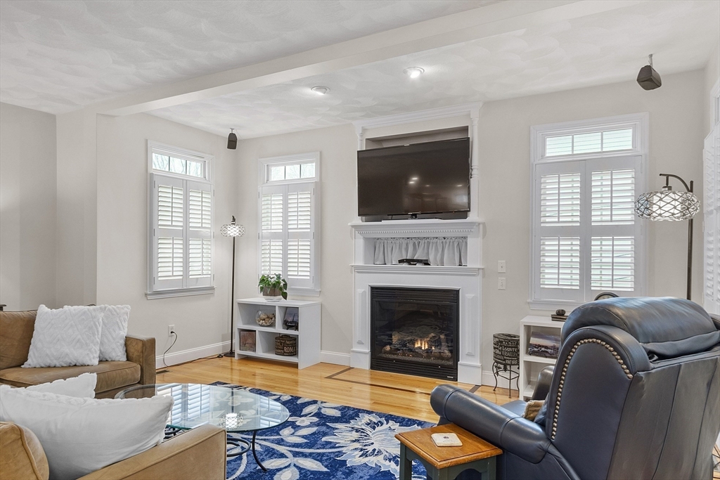 820 Main Street, Unit 1 Wakefield, MA 01880 - Photo 1 of 36 a living room with furniture a flat screen tv and a fireplace