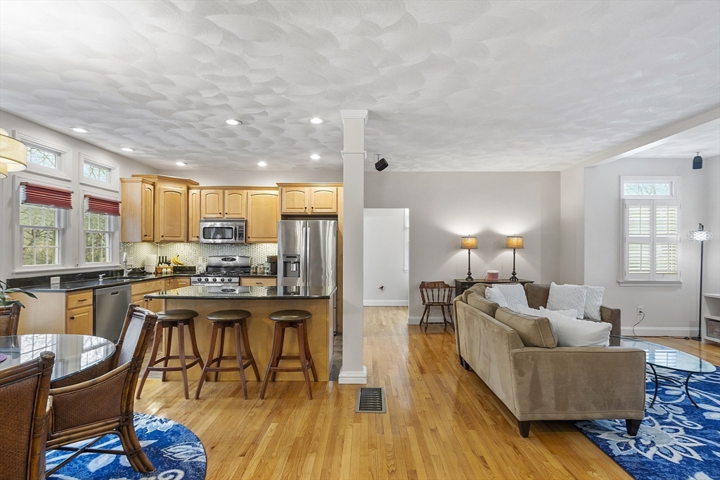 820 Main Street, Unit 1 Wakefield, MA 01880 - Photo 12 of 36 a living room with stainless steel appliances kitchen island granite countertop furniture and a wooden floor