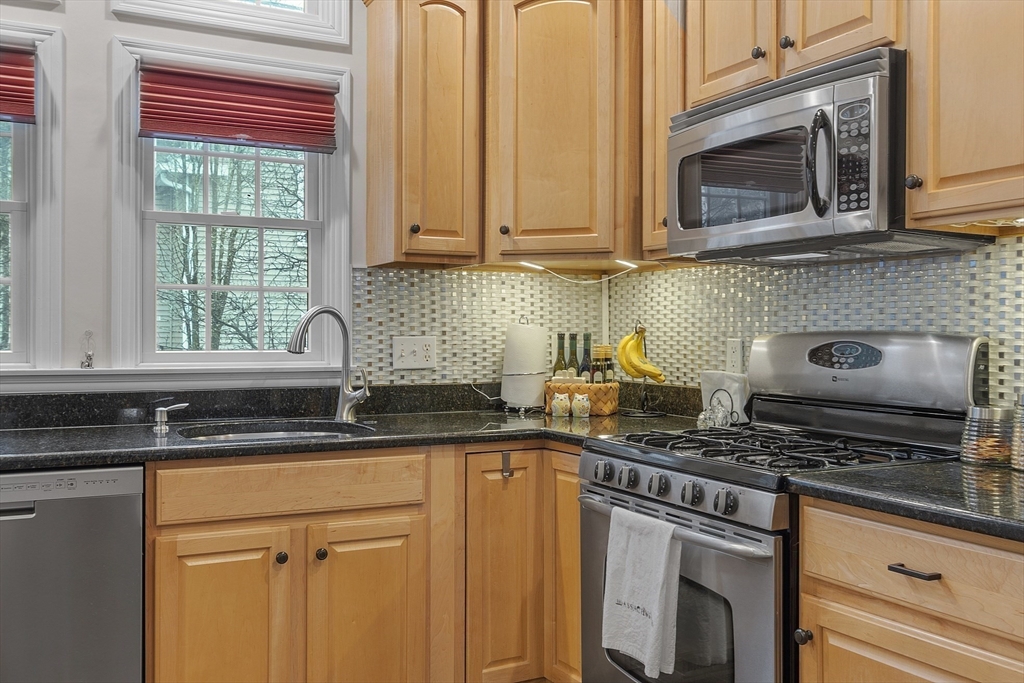 820 Main Street, Unit 1 Wakefield, MA 01880 - Photo 16 of 36 a kitchen with stainless steel appliances granite countertop a sink a stove and cabinets