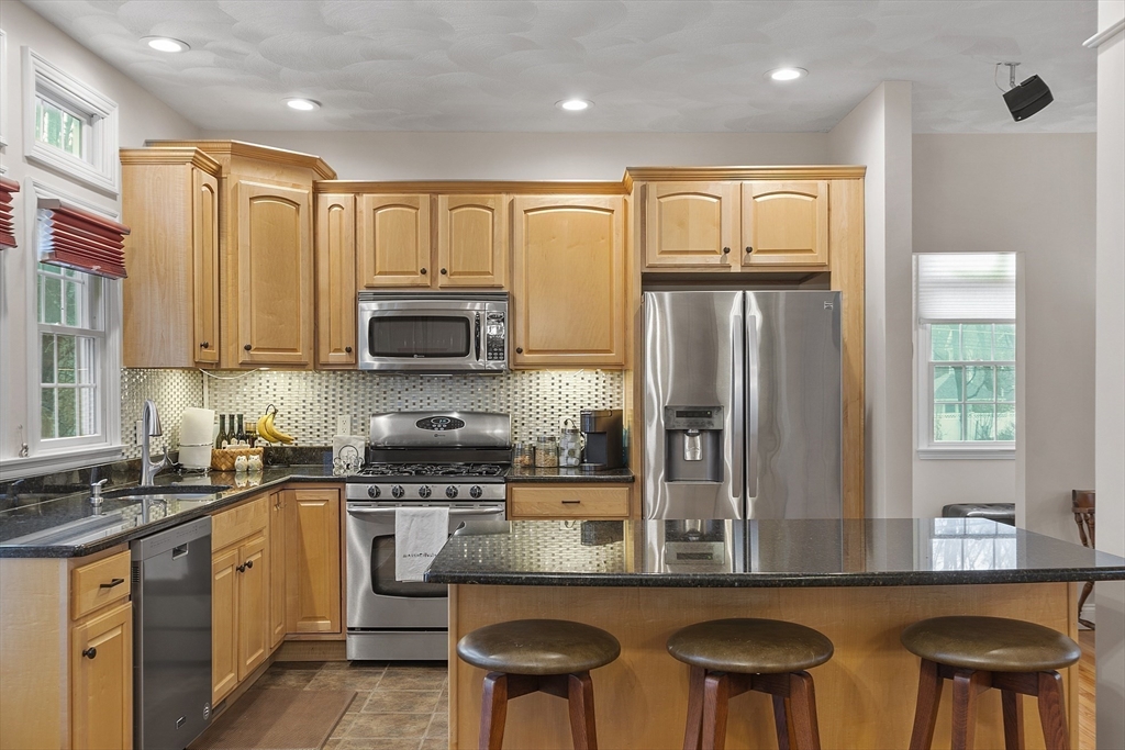 820 Main Street, Unit 1 Wakefield, MA 01880 - Photo 17 of 36 a kitchen with stainless steel appliances granite countertop a stove a sink a microwave a refrigerator and cabinets