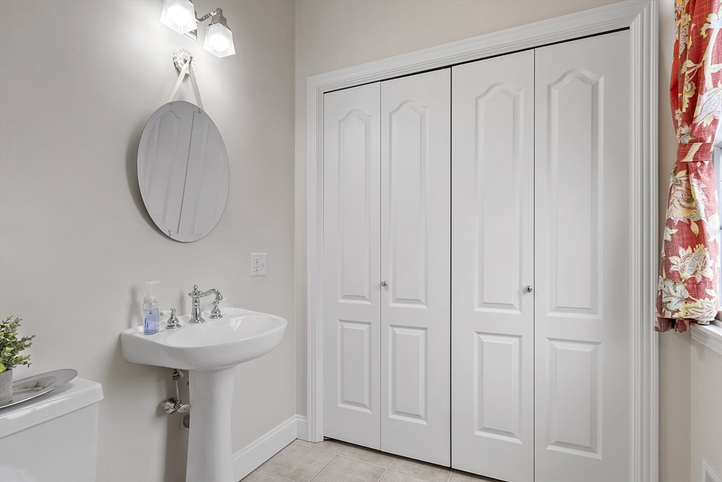 820 Main Street, Unit 1 Wakefield, MA 01880 - Photo 23 of 36 a bathroom with a sink a mirror and a shower curtain