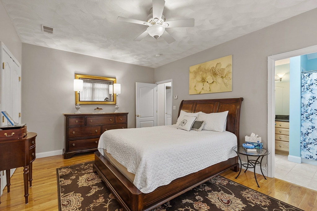 820 Main Street, Unit 1 Wakefield, MA 01880 - Photo 34 of 36 a bedroom with a bed and a chandelier