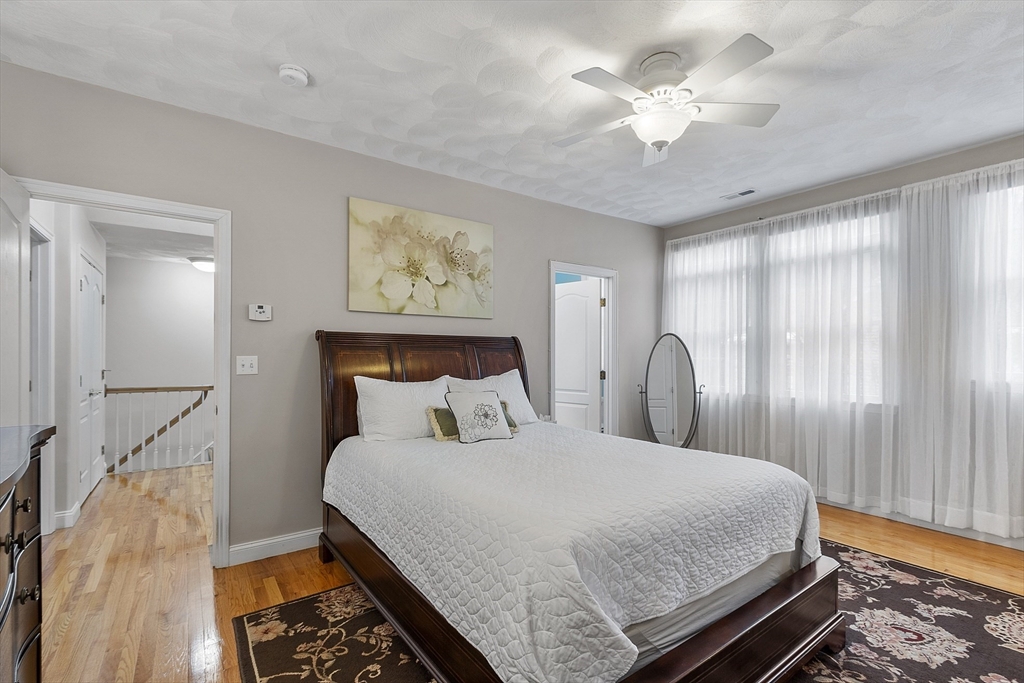 820 Main Street, Unit 1 Wakefield, MA 01880 - Photo 36 of 36 a bedroom with a large bed and a chandelier