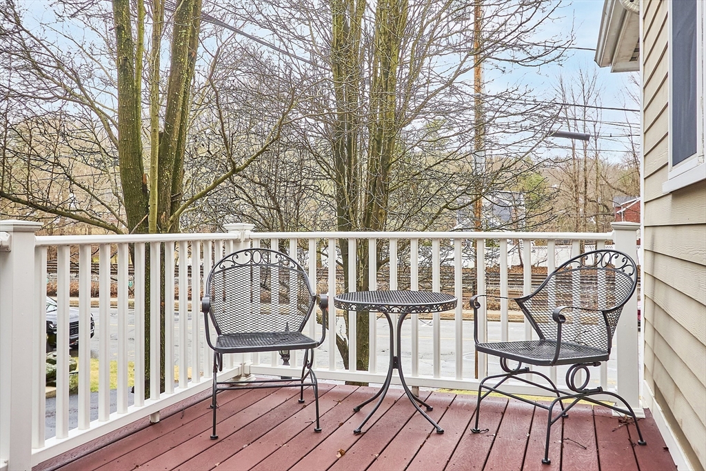 820 Main Street, Unit 1 Wakefield, MA 01880 - Photo 9 of 36 a view of a balcony with wooden floor and iron fence