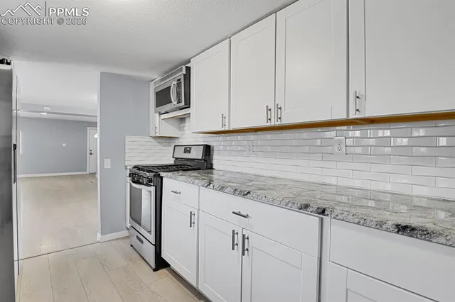 a kitchen with stainless steel appliances granite countertop a sink and a stove