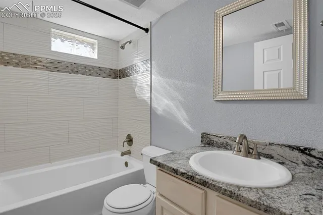 a bathroom with a granite countertop sink mirror toilet and bathtub