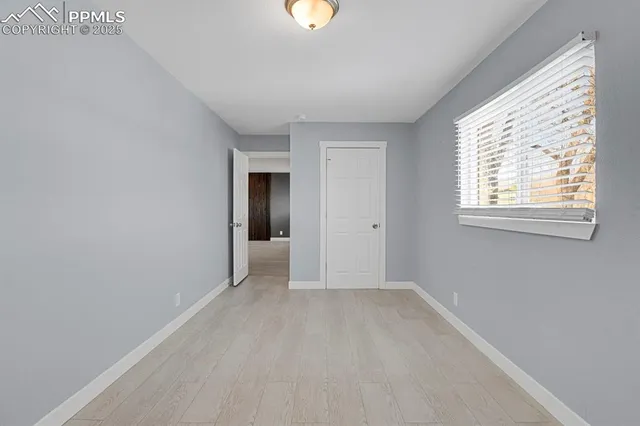 an empty room with windows and closet