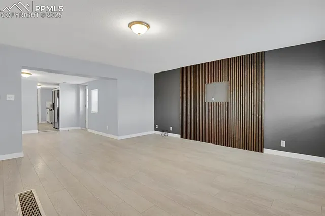 a view of an empty room with wooden floor