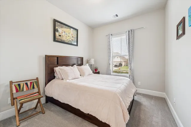 a bedroom with a bed and a painting on the wall