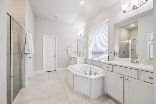 a bathroom with a tub sink and mirror