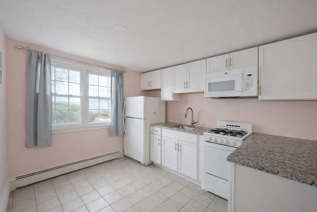 180 Tyngsboro Road, Unit 17A Chelmsford, MA 01863 - Photo 1 of 10 a kitchen with white cabinets appliances a sink and a window