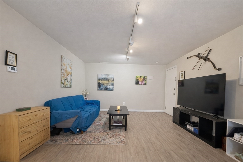 180 Tyngsboro Road, Unit 17A Chelmsford, MA 01863 - Photo 4 of 10 a living room with furniture and a flat screen tv