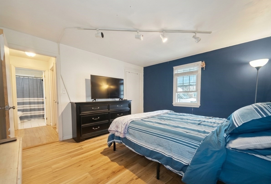 180 Tyngsboro Road, Unit 17A Chelmsford, MA 01863 - Photo 5 of 10 a bedroom with a bed and a flat screen tv