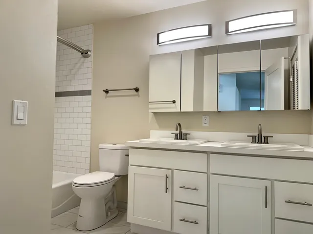a bathroom with a toilet sink a mirror and vanity