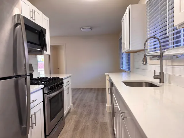a kitchen with a sink stove and refrigerator