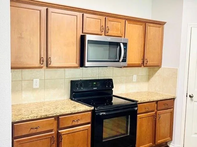 a kitchen with granite countertop cabinets stainless steel appliances and a sink
