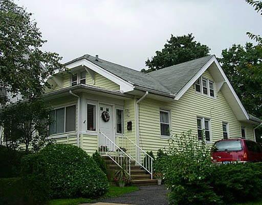 a view of a white house next to a yard