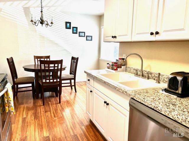 a kitchen with granite countertop stainless steel appliances a dining table and chairs