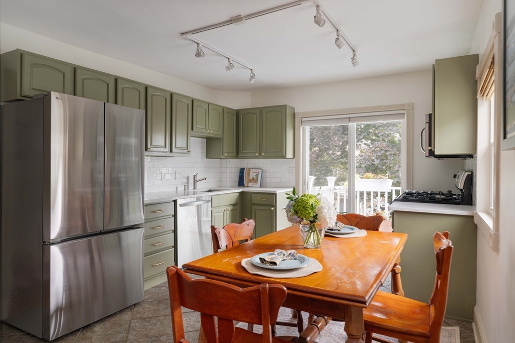 52 Victoria Street, Unit B Somerville, MA 02144 - Photo 12 of 32 a kitchen with stainless steel appliances granite countertop a refrigerator a sink a stove a dining table and chairs