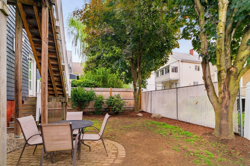 52 Victoria Street, Unit B Somerville, MA 02144 - Photo 32 of 32 a view of a patio with table and chairs and a large tree