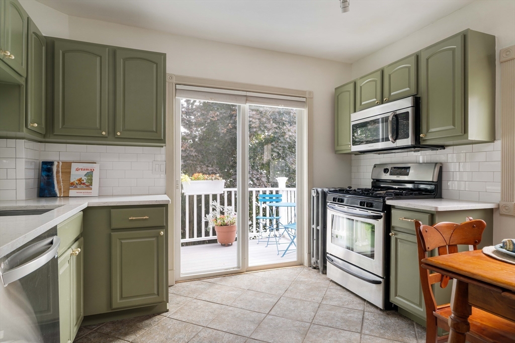 52 Victoria Street, Unit B Somerville, MA 02144 - Photo 9 of 32 a kitchen with stainless steel appliances granite countertop a stove microwave and cabinets