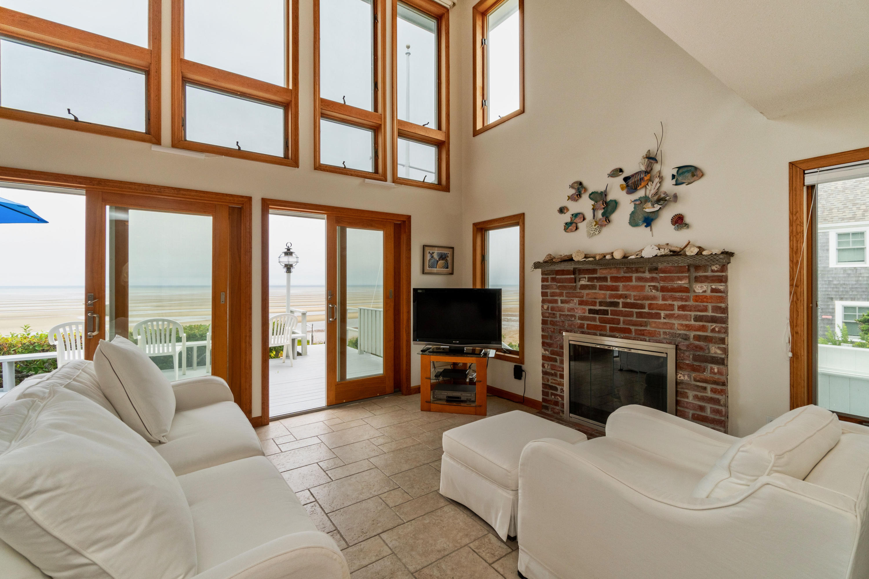 29 Bayberry Lane Eastham, MA 02642 - Photo 16 of 35 a living room with furniture a fireplace and a large window
