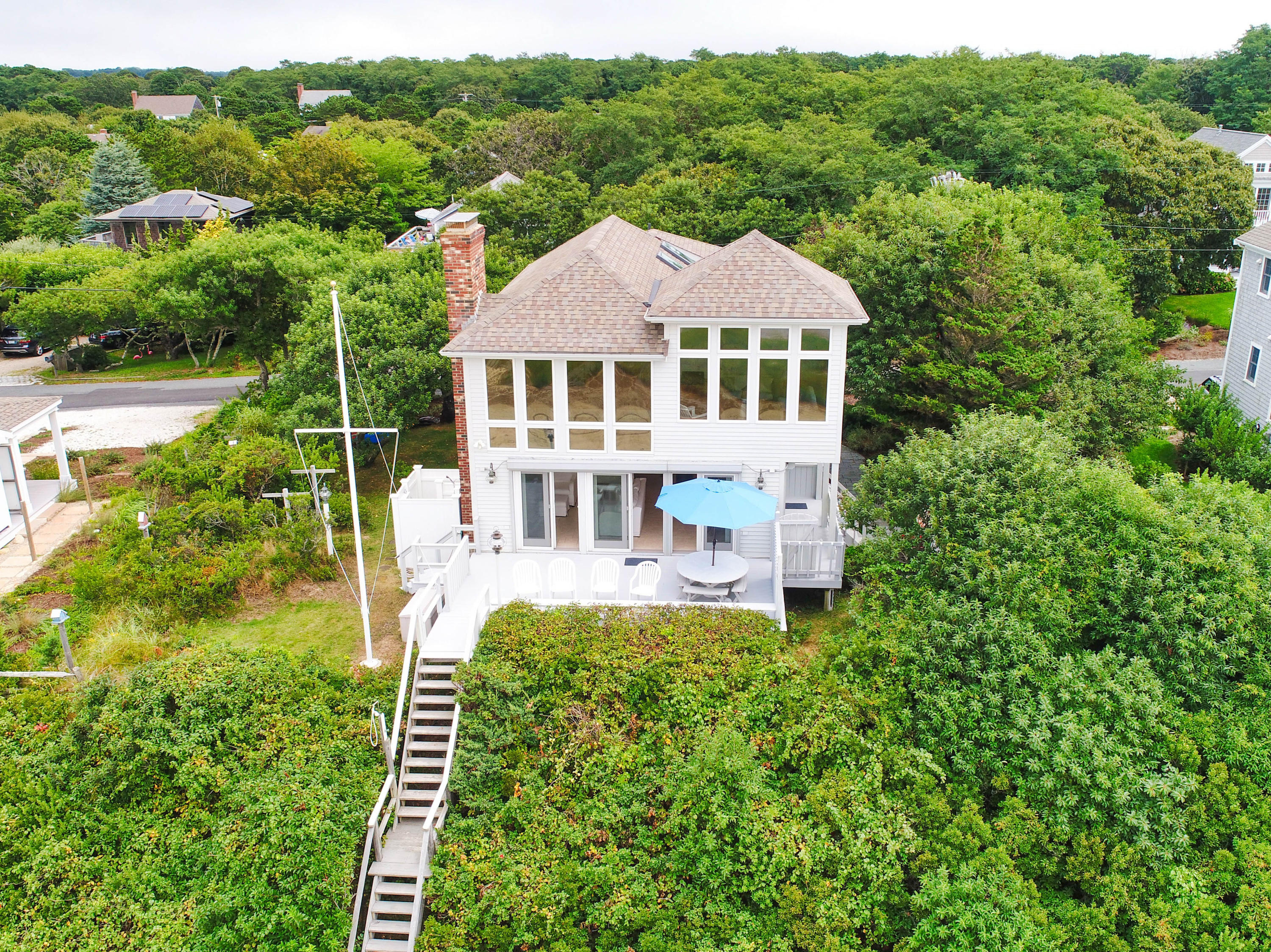 29 Bayberry Lane Eastham, MA 02642 - Photo 4 of 35 a front view of a house with a yard table and chairs