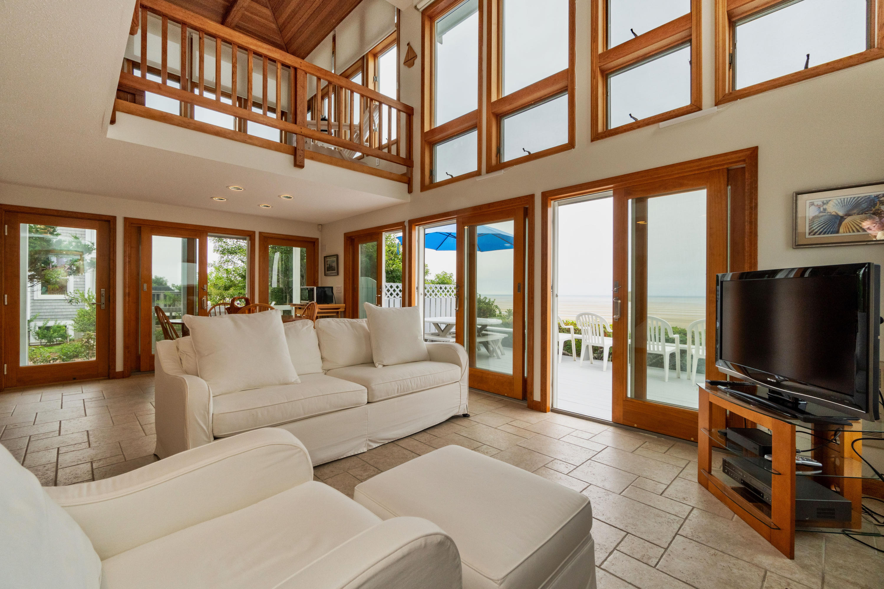 29 Bayberry Lane Eastham, MA 02642 - Photo 7 of 35 a living room with furniture a flat screen tv and a floor to ceiling window