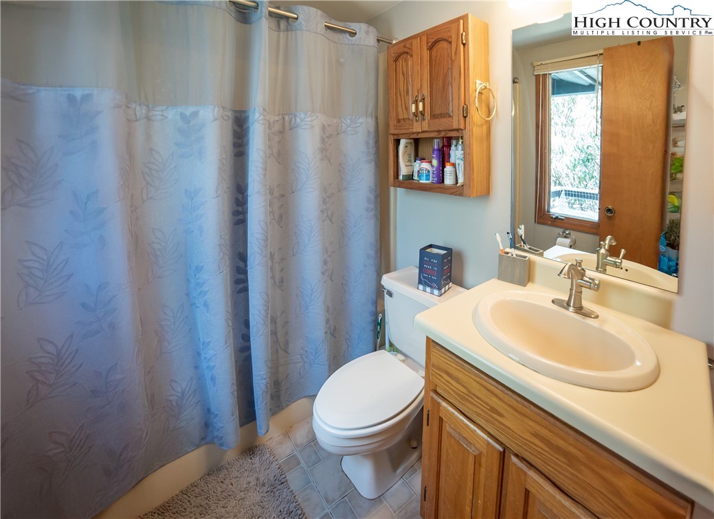 10 Locust Road Newland, NC 28657 - Photo 21 of 36 a bathroom with a sink a toilet and shower curtain