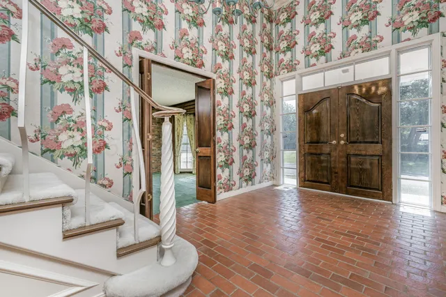 a view of an entryway with wooden floor and a front door