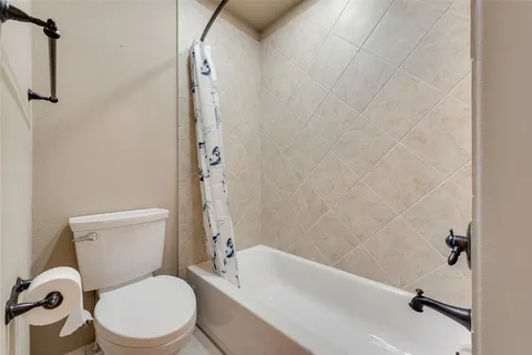 a white toilet sitting next to a bath tub