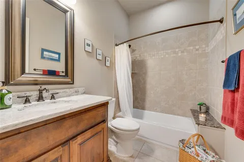 a bathroom with a sink a toilet a mirror a bathtub and shower