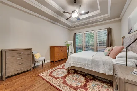 a bedroom with a large bed a chandelier and dresser