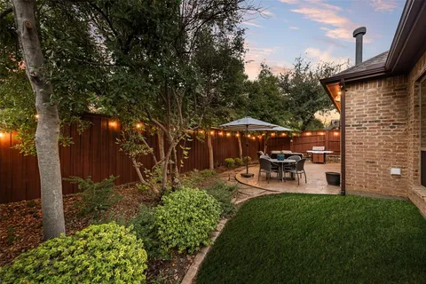 a view of a chair and table in backyard of the house