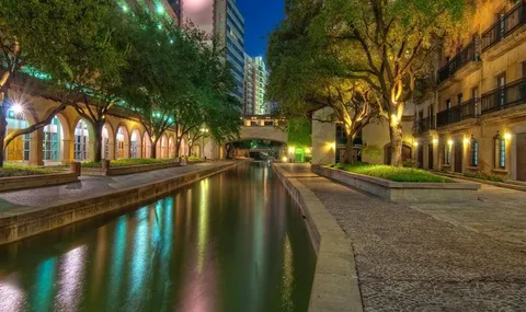 a view of swimming pool with outdoor seating and trees in the background