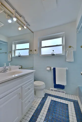 a bathroom with a toilet sink and mirror
