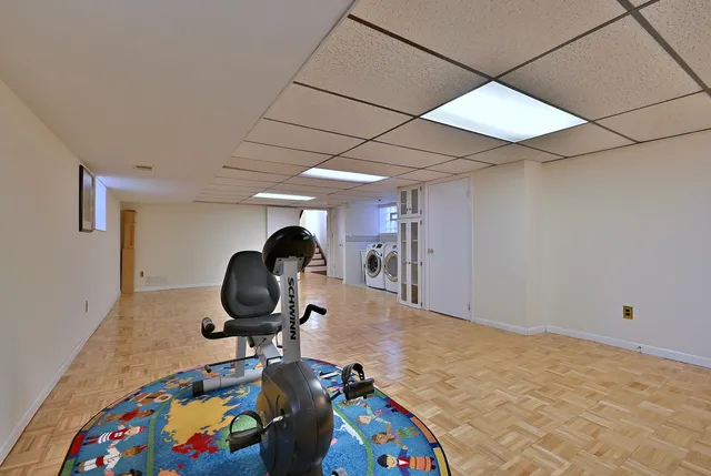 a room with gym equipment and wooden floor