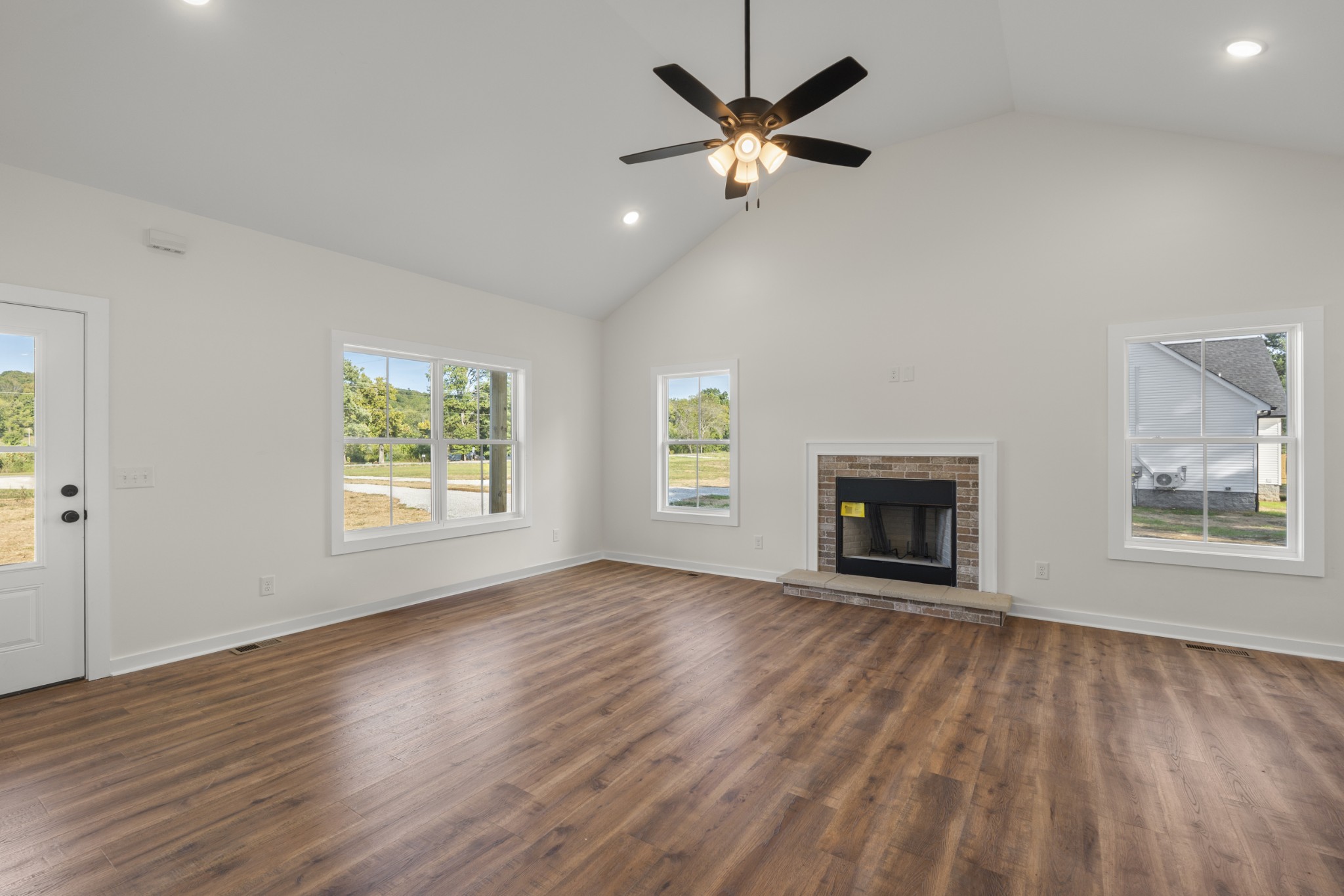 1572 Gilliam Hollow Road Dickson, TN 37055 - Photo 6 of 16 an empty room with wooden floor a ceiling fan and windows