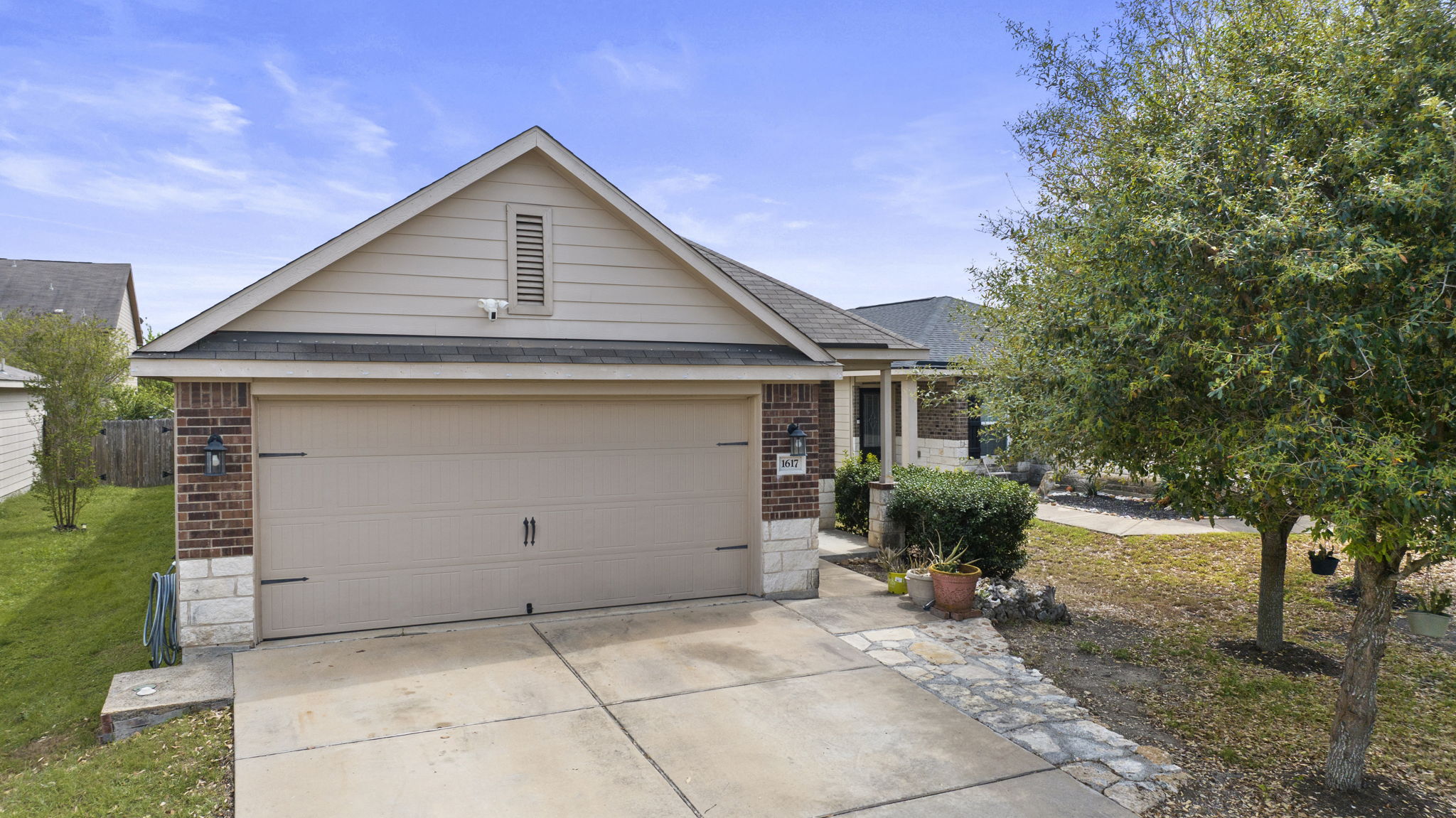 1617 Treeta Trail Kyle, TX 78640 - Photo 10 of 39 Ranch-style home with brick siding, driveway, a shingled roof, and an attached garage