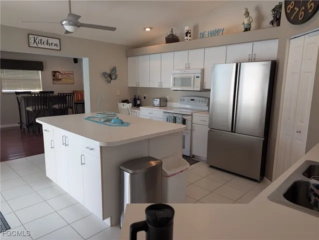 a kitchen with a sink a stove a refrigerator and white cabinets