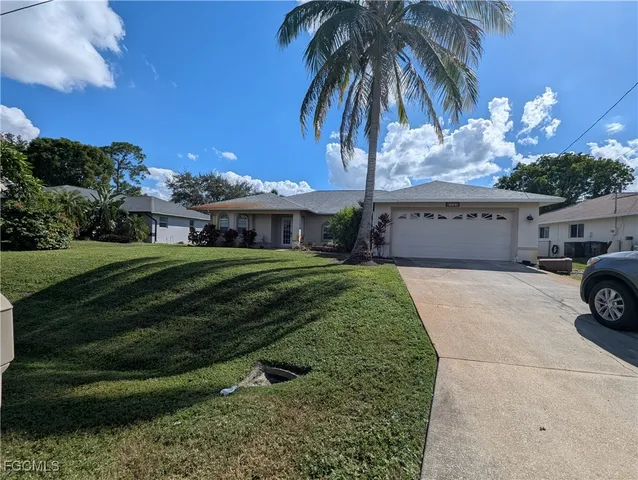 a view of a house with a yard and potted plants
